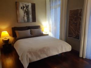 a bedroom with a large white bed with two lamps at Duplex T4 Sempre Endavant in Vernet-les-Bains