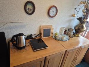 a desk with a laptop and a clock on the wall at Cozy Nook Stays near Rogla & Terme Zreče in Zreče