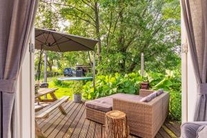 a patio with a table and an umbrella at farmhouse in Wijdewormer +16 photos