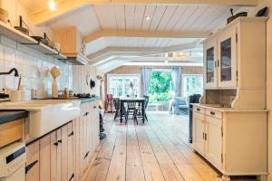 a kitchen with white cabinets and a wooden floor at farmhouse in Wijdewormer