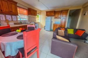 a kitchen and living room with a table and a couch at Sk SHaven #2 in Castries