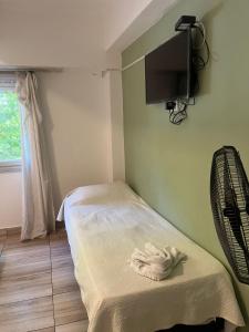 a room with a bed with a tv on the wall at Cala Hotel MDP in Mar del Plata