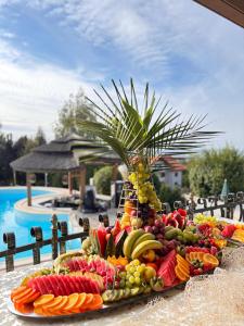 a tray of fruit on a table next to a pool at Cardinale Resort in Iaşi