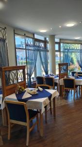 a dining room with tables and chairs and windows at Grot Hotel in Malbork