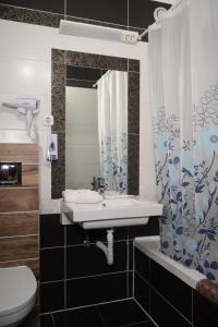 a bathroom with a sink and a toilet and a mirror at Hotel Amadeus in Budapest +57 photos