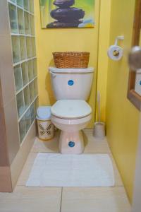 a bathroom with a toilet with a basket on top of it at Sk SHaven #2 in Castries