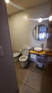a bathroom with a toilet and a sink and a mirror at Cala Hotel MDP in Mar del Plata +35 photos