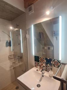 a bathroom with a sink and a shower and a mirror at Alba Odeceixe - casa clara in Odeceixe +19 photos