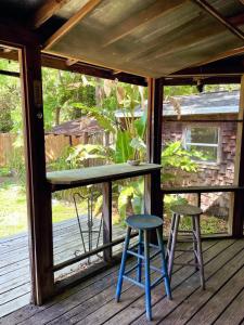 a screened in porch with two stools and a table at Creatives Retreat for Artists & Lovers in Gainesville