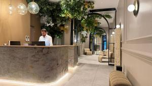 a man standing at a counter in a lobby at Bobo's hotel in Paris