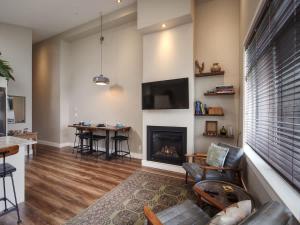 a living room with a fireplace and a table at Oceanfront Marina & Mountain views- pet friendly in Port Renfrew
