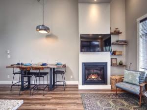 a living room with a table and a fireplace at Oceanfront Marina & Mountain views- pet friendly in Port Renfrew