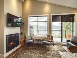 a living room with a fireplace and a couch and chairs at Oceanfront Marina & Mountain views- pet friendly in Port Renfrew