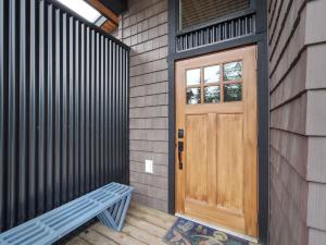 a wooden door on the side of a house with a bench at Oceanfront Marina & Mountain views- pet friendly in Port Renfrew