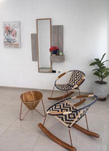 two chairs and a mirror in a room at Hotel Barcelona in Montería