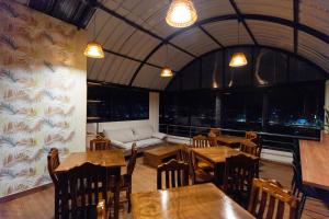 a restaurant with tables and chairs and a couch at Samaran Wuasi in Puno