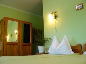 a bedroom with a bed with white pillows on it at Cabana Delfinul - Cazanele Dunarii in (( Plavişeviţa ))