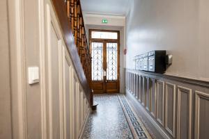 a hallway with a wooden door with a window at L'Haussmannien - Hyper centre-ville Evreux in Évreux +14 photos