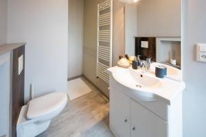 a white bathroom with a toilet and a sink at L'Haussmannien - Hyper centre-ville Evreux in Évreux