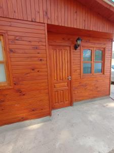 a wooden garage with two doors and windows at Cabaña Mailin in Uspallata