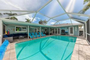 a swimming pool with a glass roof over a house at Island Paradise Villa RNT-01125 in Cape Coral