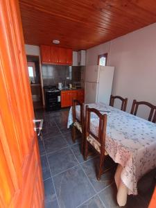 a kitchen with a table and a white refrigerator at Cabaña Mailin in Uspallata