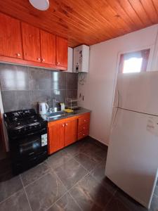 a kitchen with a stove and a refrigerator at Cabaña Mailin in Uspallata +3 photos