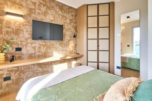 a bedroom with a tv on the wall and a bed at A la plage R in San Benedetto del Tronto