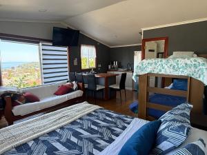 a bedroom with a bunk bed and a living room at Hostal y Cabañas Mirando al Mar in Puerto Montt
