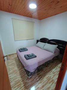a bedroom with a bed with a whiteboard on the wall at Cabaña Mailin in Uspallata