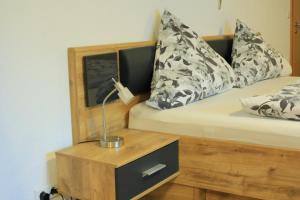 a bed with a night stand with a lamp on it at Albglück in Gammertingen