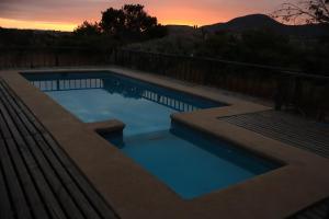 a swimming pool with a sunset in the background at Cabañas Guanaqueros Arriendo Diario in Guanaqueros +15 photos