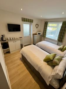 a bedroom with two beds and a television in it at Acorns in Hordle