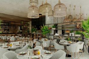 a restaurant with white tables and chairs and chandeliers at Kampala Marriott Hotel in Kampala