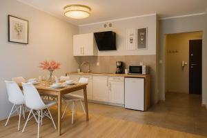 a kitchen and dining room with a table and chairs at TK Apartments Spiżowa in Wrocław