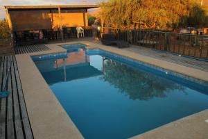 a swimming pool with blue water in a backyard at Cabañas Guanaqueros Arriendo Diario in Guanaqueros