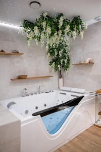 a bathroom with a bath tub with a plant at L'Escapade Etoilée Rosheim in Rosheim +26 photos