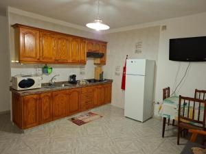 a kitchen with wooden cabinets and a white refrigerator at Solo Tranquilidad in Mocanal