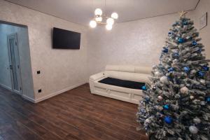 a living room with a christmas tree and a couch at Корчин Гарден Шале in Korchin
