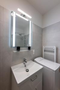 a white bathroom with a sink and a mirror at Eternity Apartment in Štúrovo +22 photos