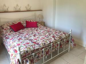 a bed with red pillows on it in a bedroom at The Studio in Wisborough Green