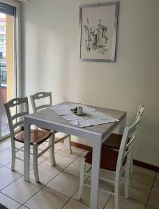 a dining room table and chairs with a table and a picture at Le piscine in Villa Guardia +5 photos