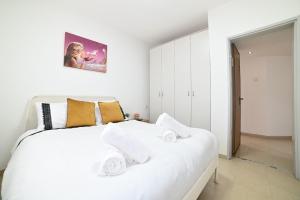 a bedroom with a white bed with towels on it at גייט טו כנרת- פנטהאוז 4 חדרים עם שולחן ביליארד- ממד בדירה in Tiberias