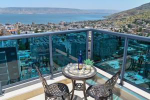 a table and chairs on a balcony with a view at גייט טו כנרת- פנטהאוז 4 חדרים עם שולחן ביליארד- ממד בדירה in Tiberias
