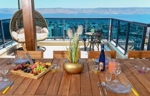 a table with a bowl of fruit on a balcony at גייט טו כנרת- פנטהאוז 4 חדרים עם שולחן ביליארד- ממד בדירה in Tiberias