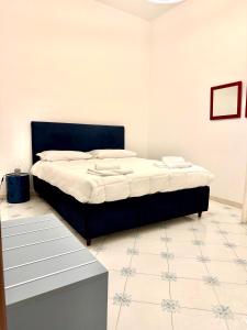 a bedroom with a bed with a black headboard at Dimora dei Mercanti in Salerno