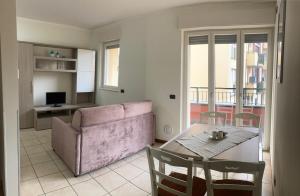 a living room with a pink couch and a table at Le piscine in Villa Guardia
