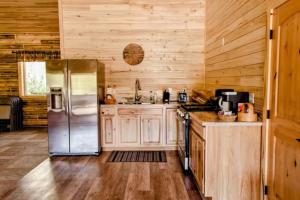 a kitchen with wooden walls and a stainless steel refrigerator at Alaska Knotty Pine Whole Building in Palmer