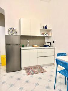 a kitchen with white cabinets and a stainless steel refrigerator at Dimora dei Mercanti in Salerno