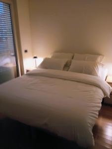 a large white bed in a bedroom with a window at Le piscine in Villa Guardia